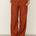 Naz women's linen trousers for summer in red. High-waisted and wide leg fit. Features front pleats and side pockets. 