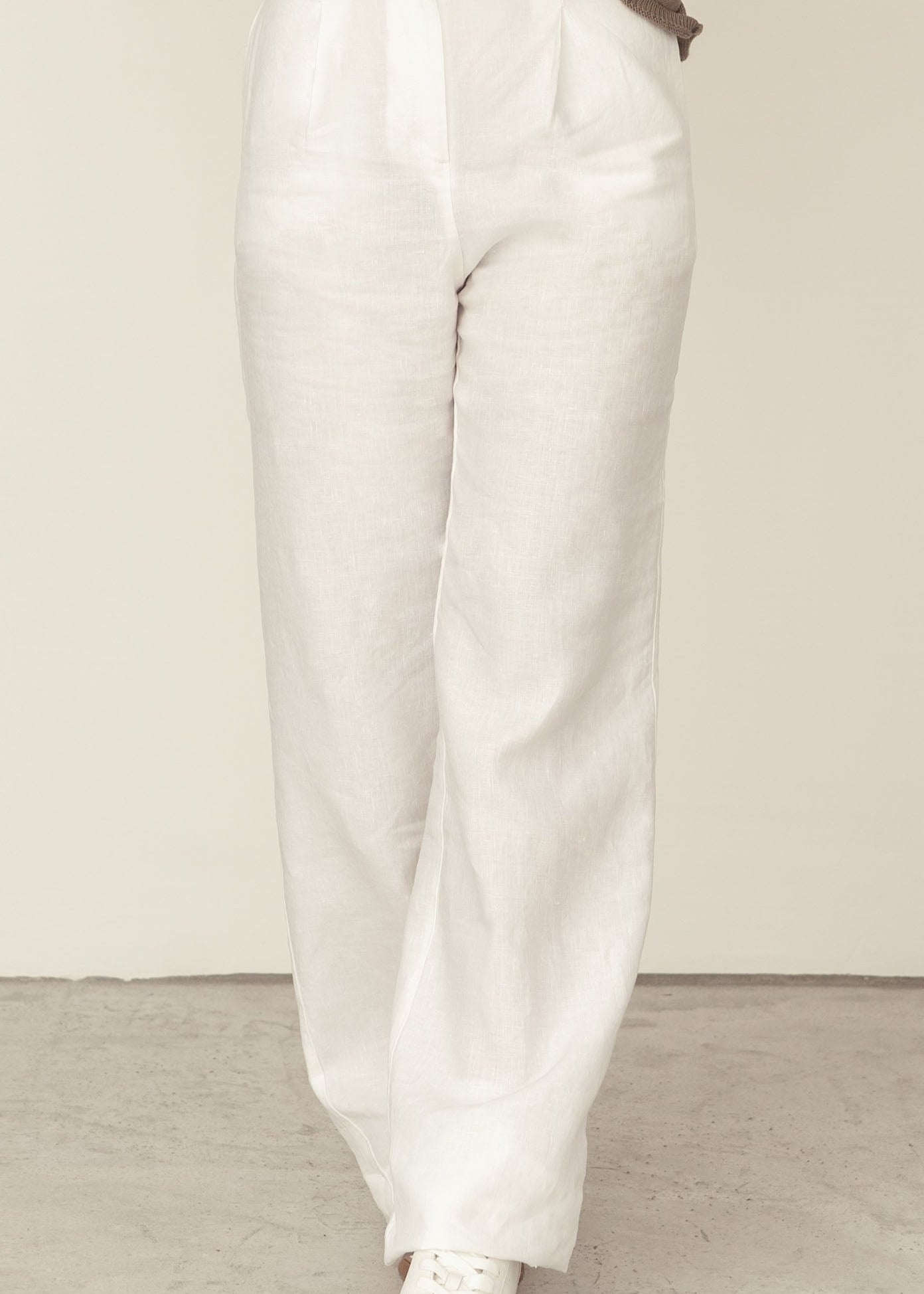 Naz women's high waisted linen trousers in white. Tailored fit with side pockets. Made sustainably in Portugal.