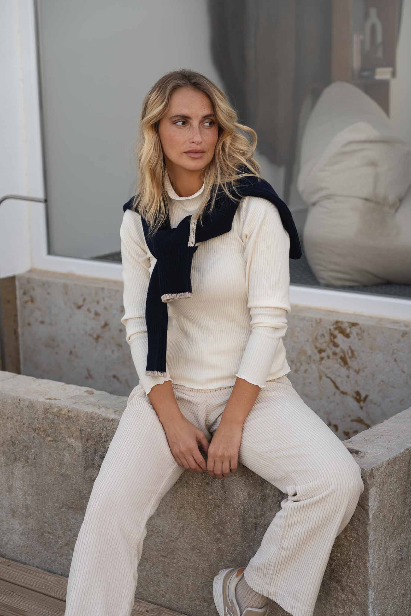 NAZ Ava Turtleneck in White. Made with 100% Deadstock Cotton. Produced ethically in Portugal. Paired with the Mar Tencel Trousers in White and the Agnes Wool Sweater in Navy