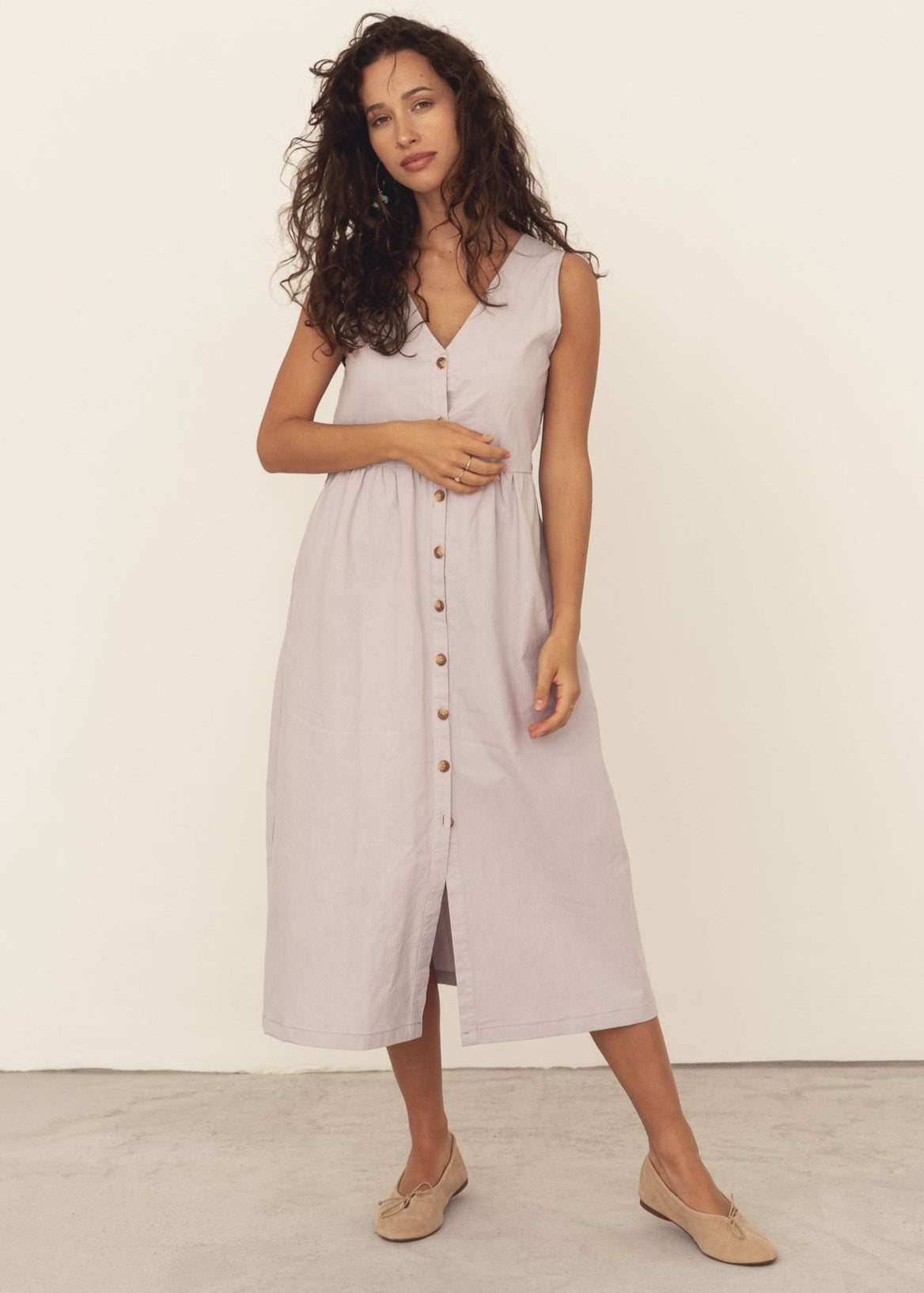 Women's sleeveless cotton dress with a deep v-neck and buttoned front in lilac. Made sustainable in Portugal from deadstock cotton.