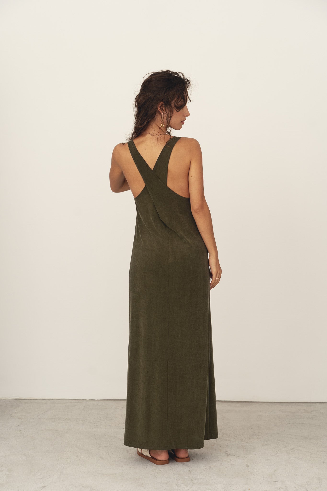 Naz women's cupro midi summer dress in dark green. Features side slit high neckline cross-over back. Made sustainably in Portugal.