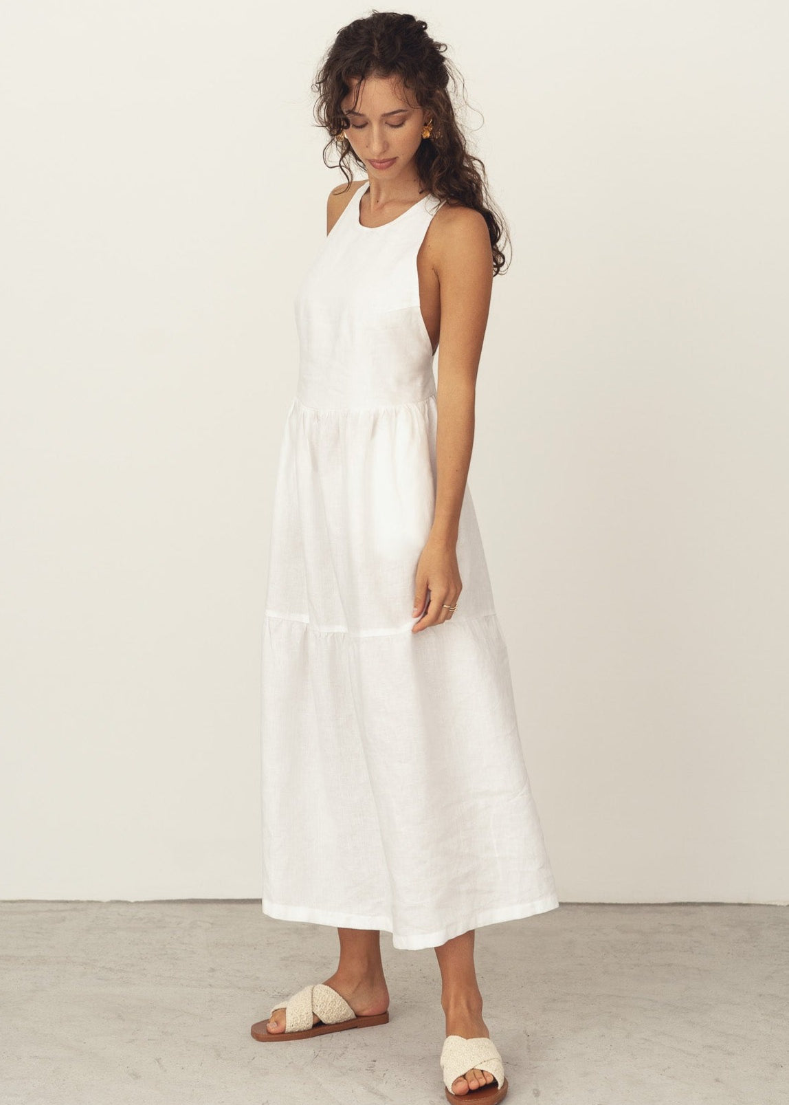 Naz's women's linen midi dress in white. Features a halter neck and crossed back straps. Made in Portugal.