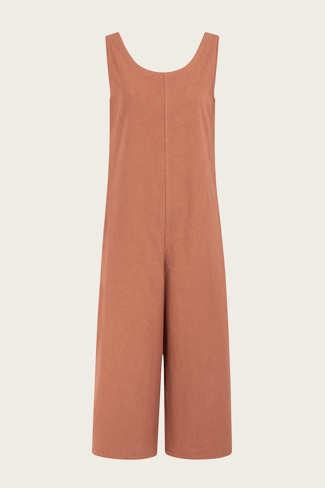 Naz women's jumpsuit in peach. Features a straight fit hidden pockets and deep back v-neckline.
