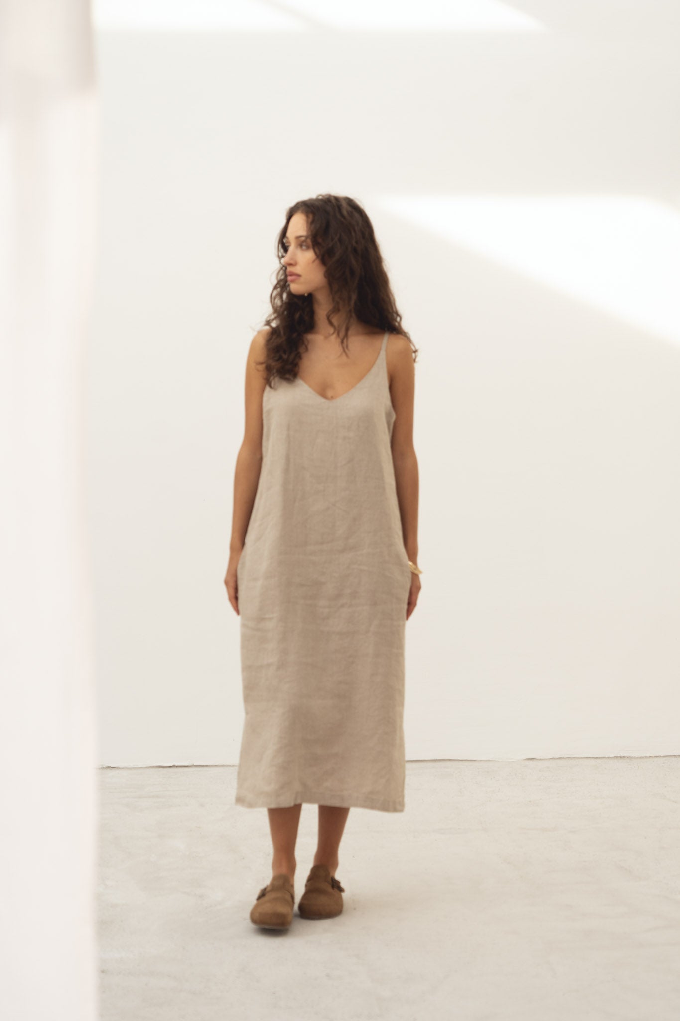 Naz women's linen summer dress in beige. Made in Portugal for lasting quality. Features thin straps v-neck and hidden side pockets. 