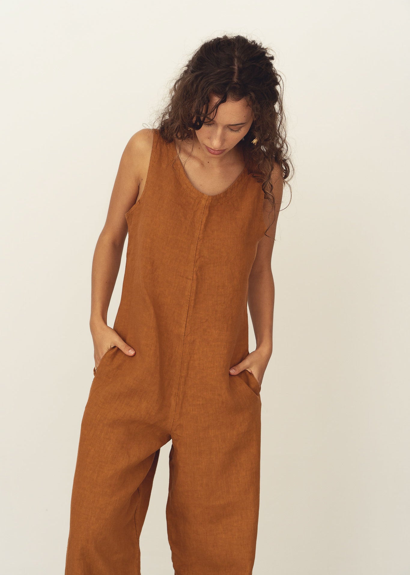 Naz women's breathable linen romper in rust. Features a straight fit and a deep v-neckline. Made in Portugal. 