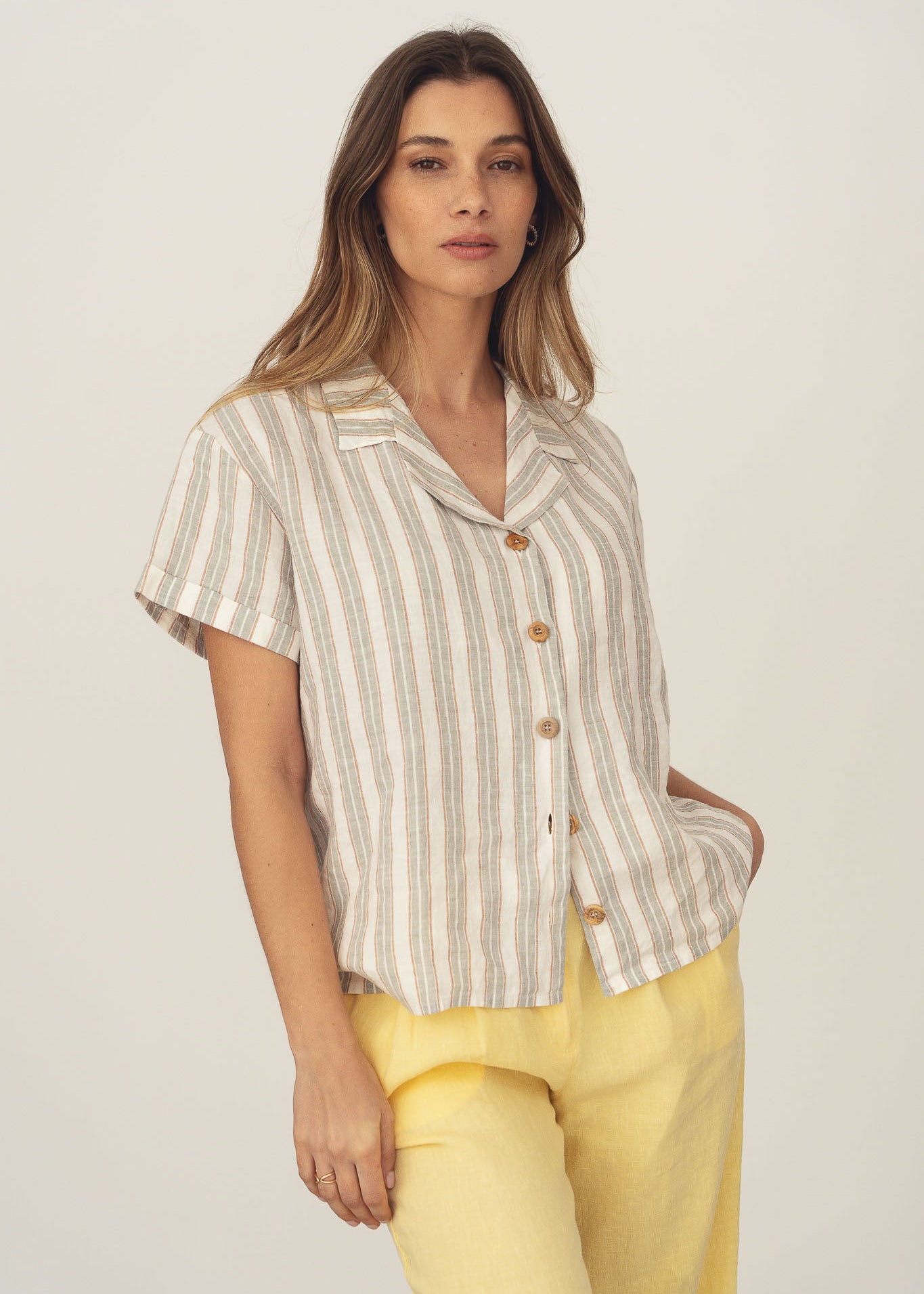 Women's short-sleeve linen blouse with grey stripes. Features a lapel collar and wooden buttons. Made in Portugal.