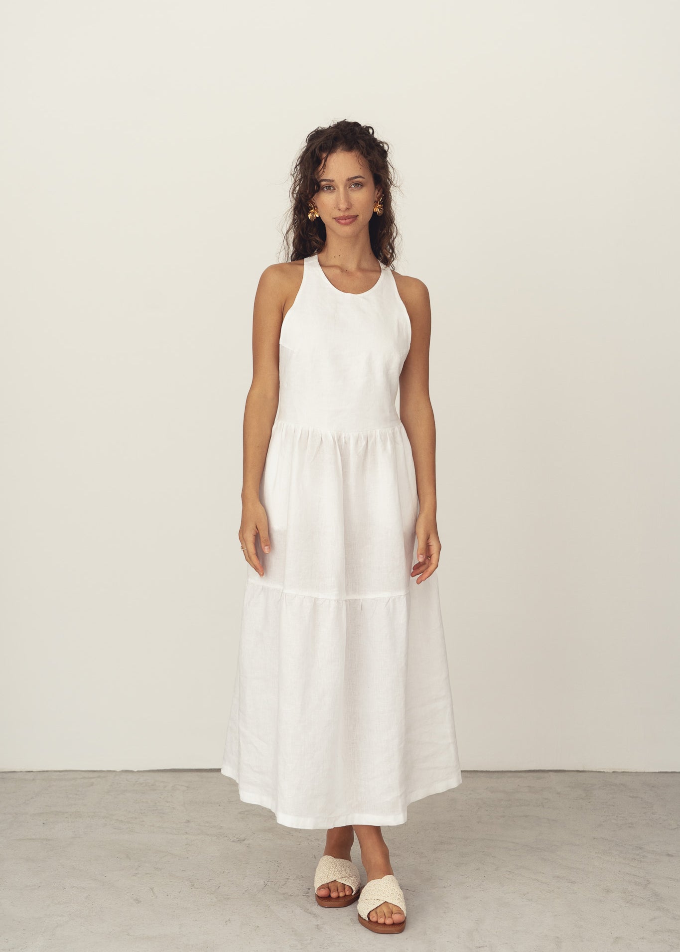 Naz's women's linen midi dress in white. Features a halter neck and crossed back straps. 