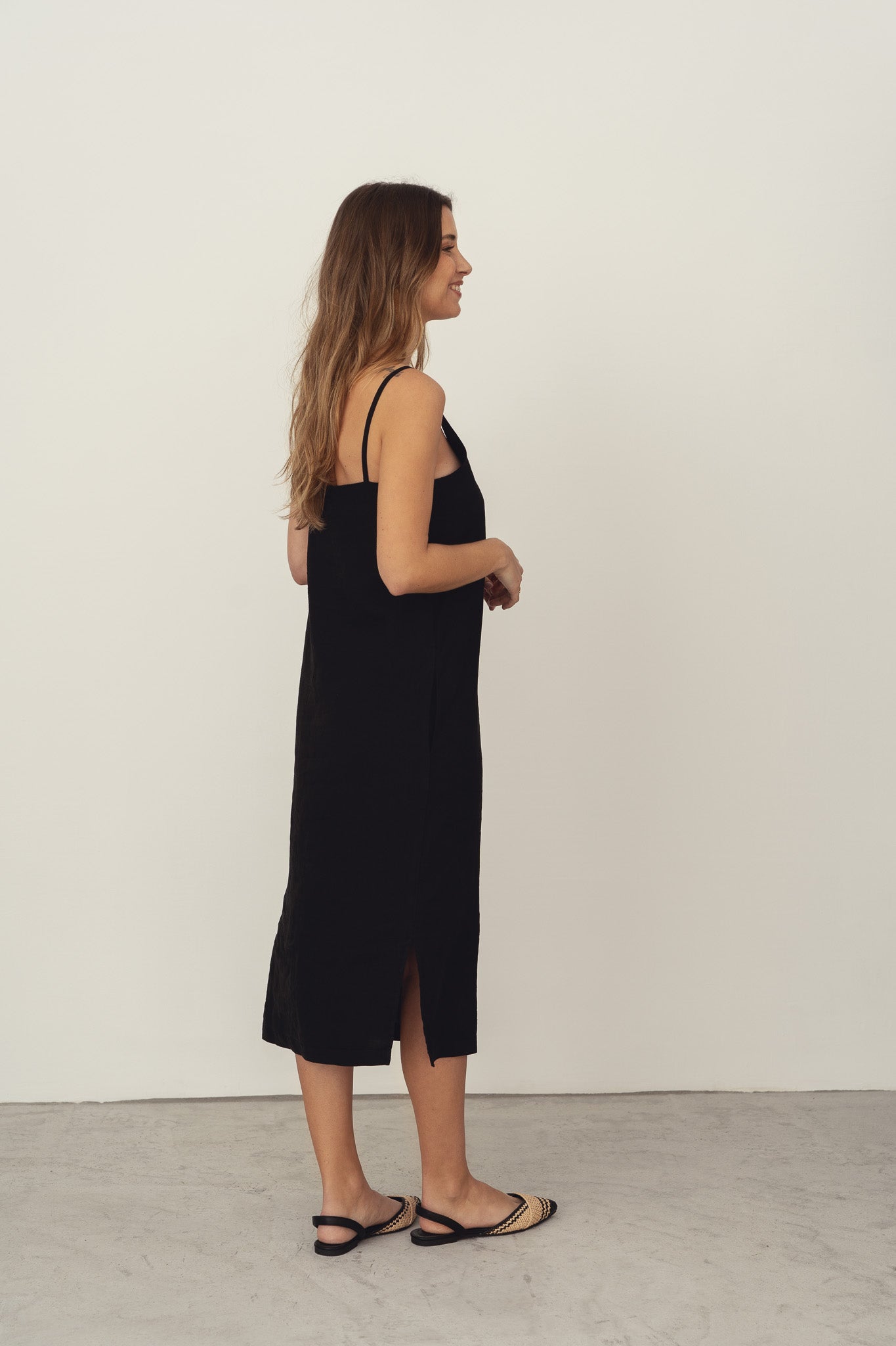 Naz's women's sustainable midi linen dress in black. Features thin straps, double fabric across the bust with hidden side pockets. 